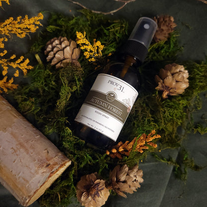 Bottle of Prov 31 Autumn Forest Room Spray on a natural background with moss and pine cones.
