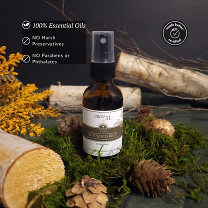 Bottle of Prov 31 Autumn Forest room spray with natural elements on a dark background