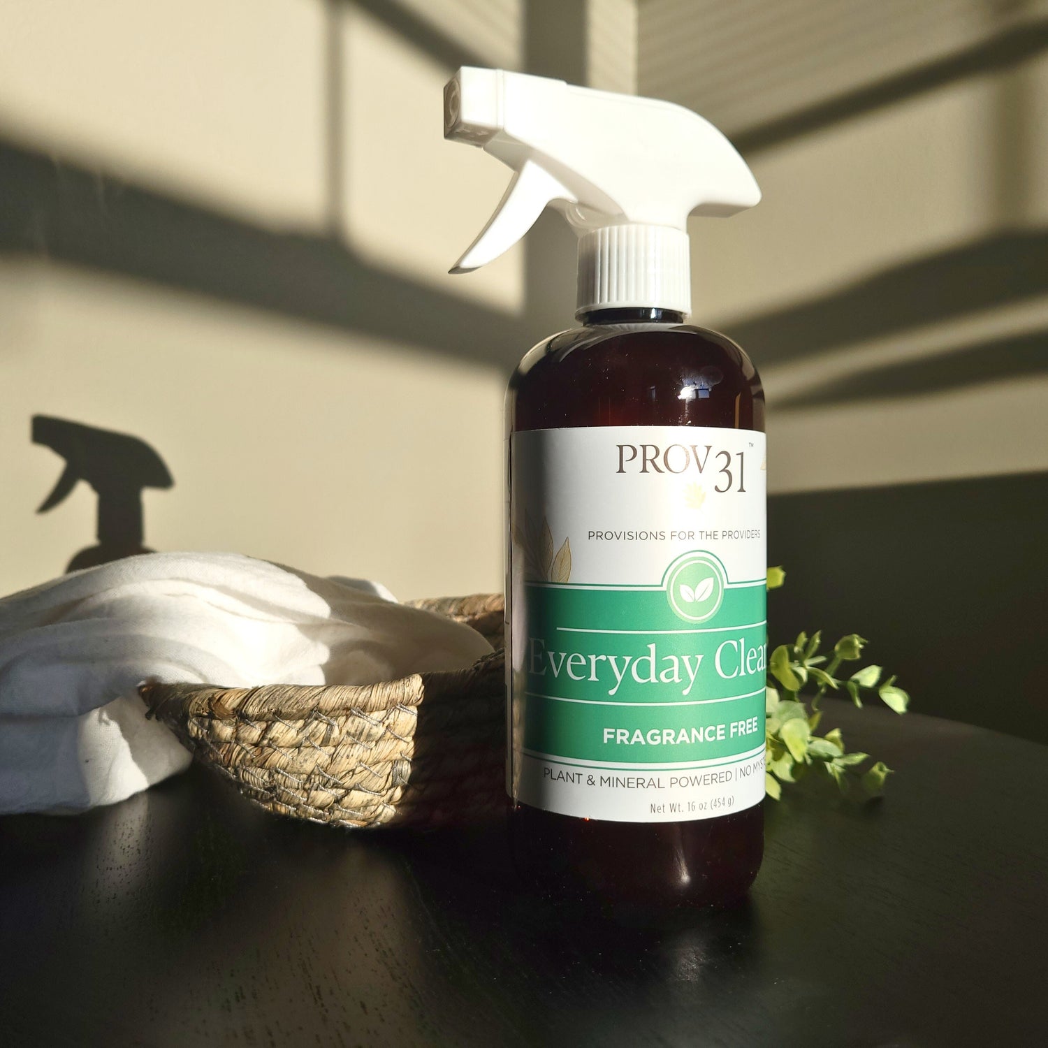 Bottle of Prov31 Everyday All Purpose fragrance-free cleaning spray on a table with a cloth and basket in the background.