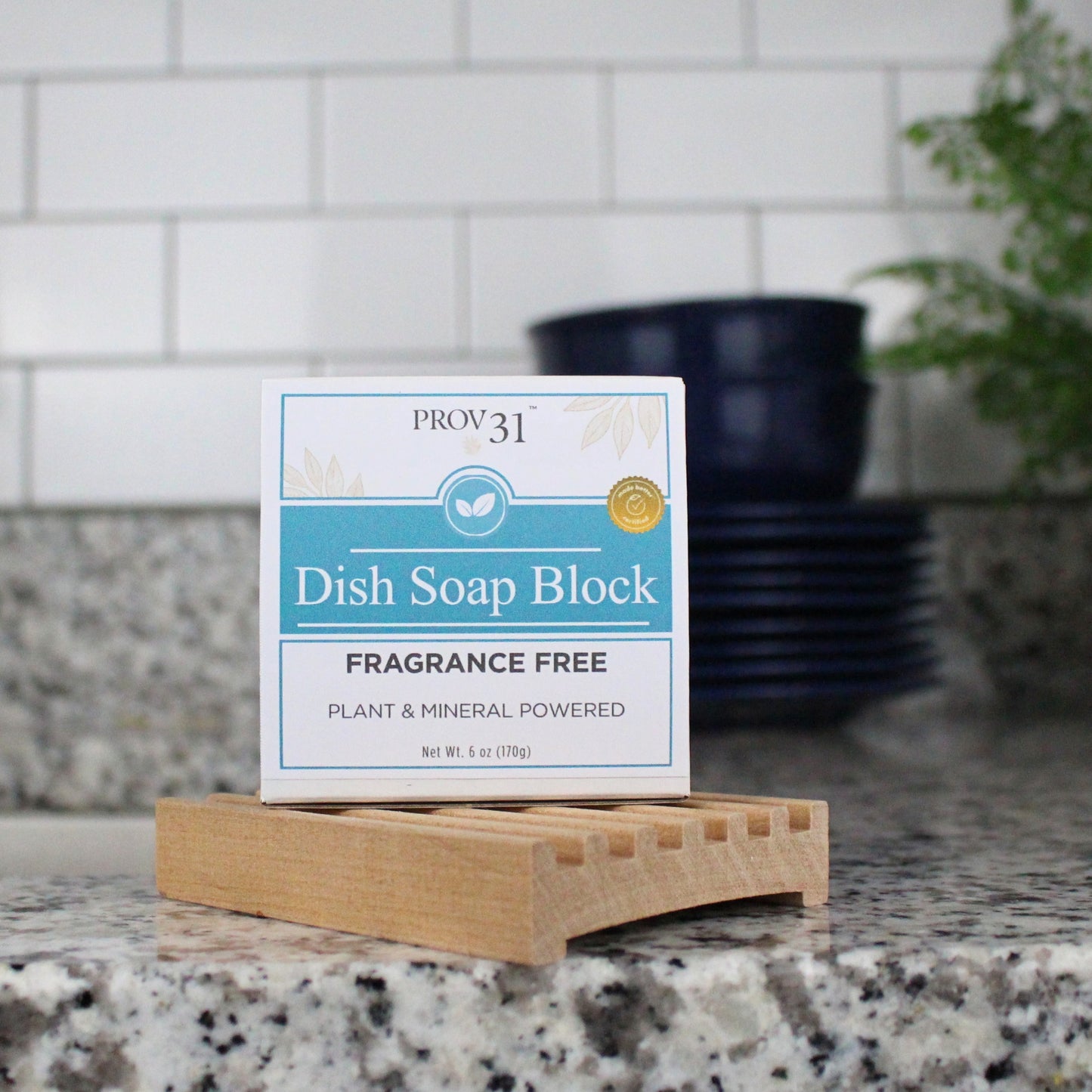 Prov 31 dish soap block on a countertop next to a sink, dishes, and plant.