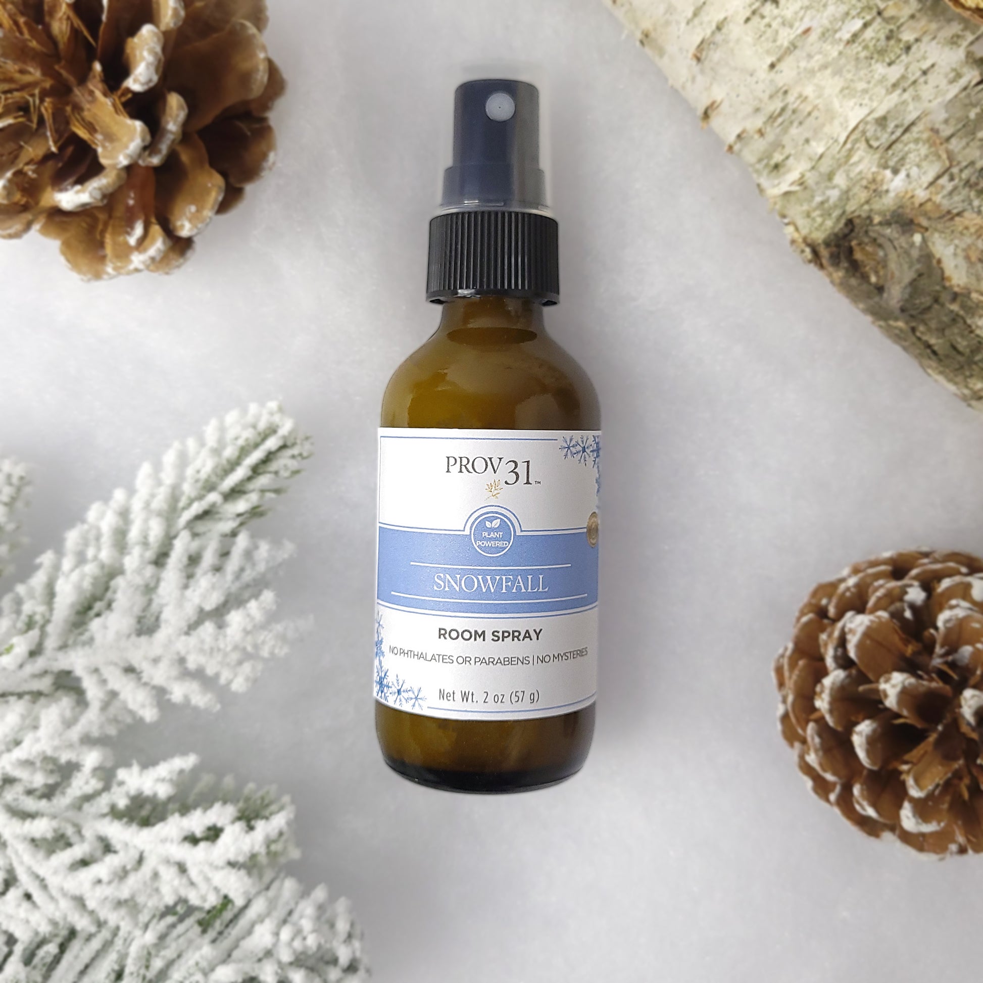 Natural room spray bottle labeled 'Snowfall' by PROV 31 with pinecones and snow