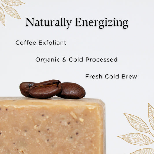 Close up of Prov 31 natural soap bar with coffee beans on a white background, next to text about fresh cold brew, coffee exfoliants, and organic and cold-processed ingredients.