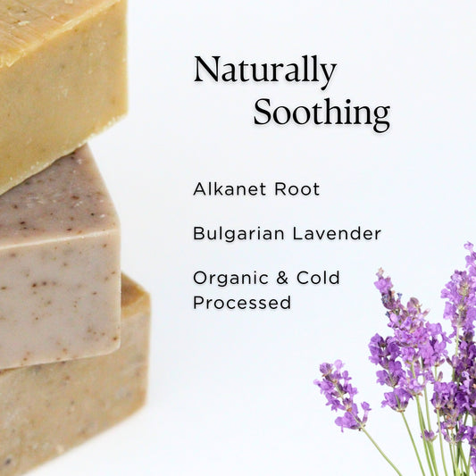 Three bars of prov 31 natural soaps  with a stack of lavender flowers on a white background, labeled 'Naturally Soothing' with organic ingredients listed.