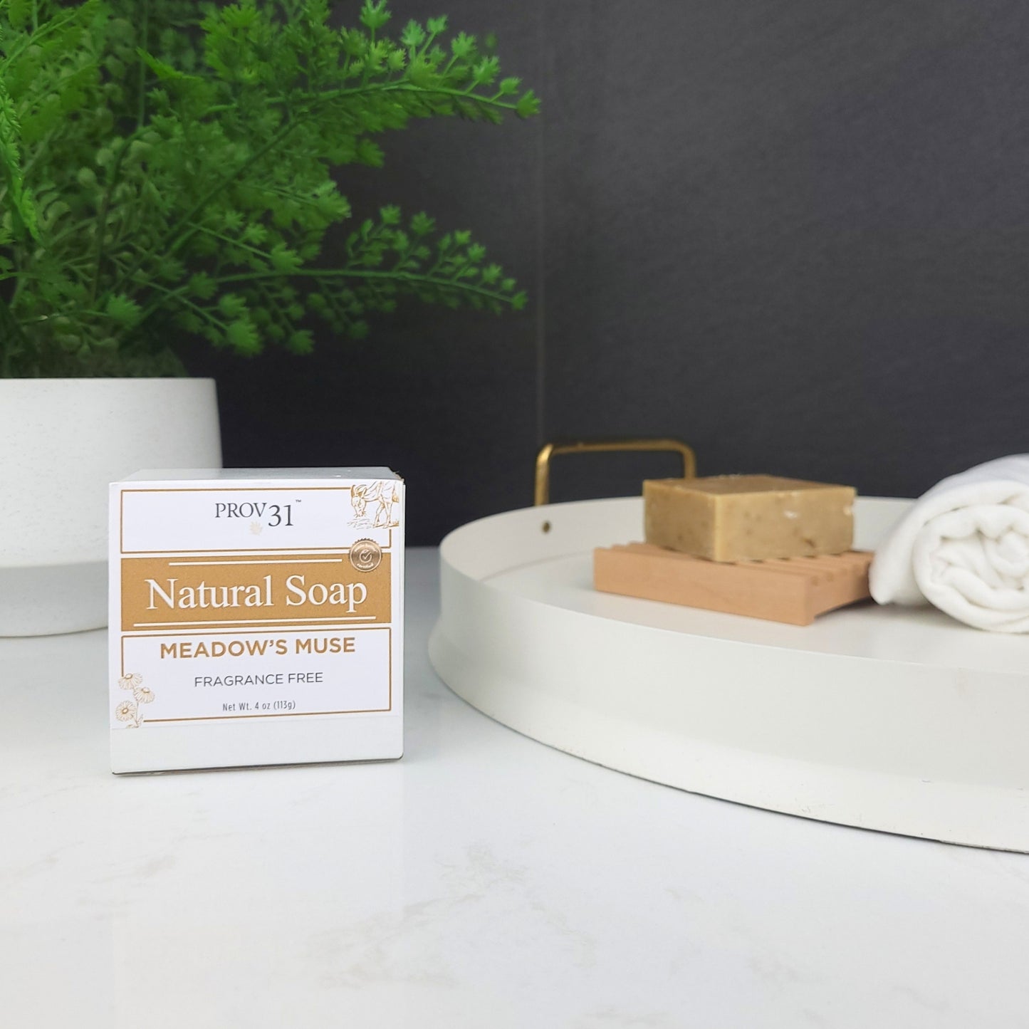 Prov 31 Natural Soap bar and packaging on a marble bathroom countertop with a plant and towel in the background