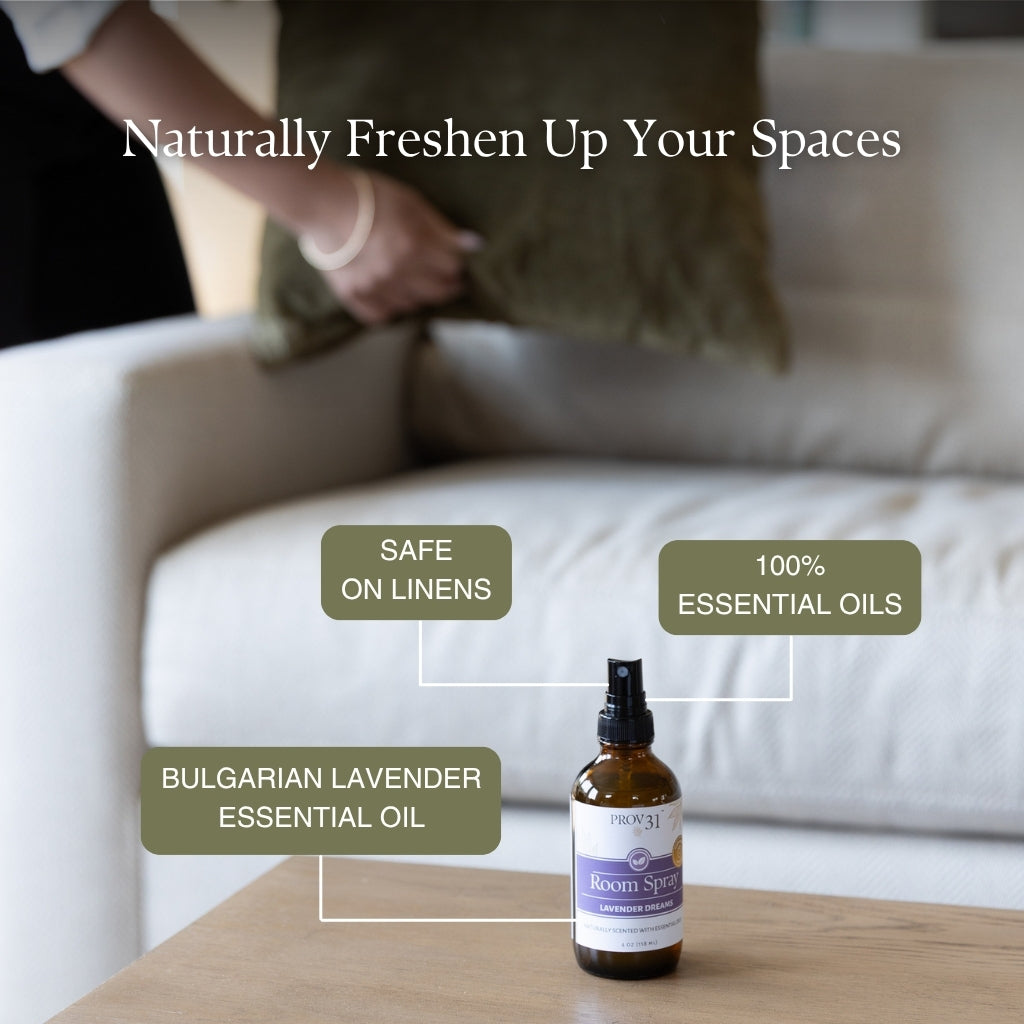 A bottle of PROV 31 room spraywith  essential oils sits on a wooden table in front of a blurred living room background with a person fluffing a pillow. Text overlays highlight features like 'Naturally Freshen Up Your Spaces', 'Safe on Linens', '100% Essential Oils', and 'Bulgarian Lavender Essential Oil'.