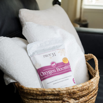 A bag of PROV 31 Oxygen Booster placed in a woven basket with white towels in a cozy living room setting.