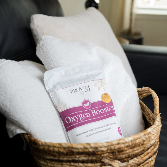 A bag of PROV 31 Oxygen Booster placed in a woven basket with white towels in a cozy living room setting.